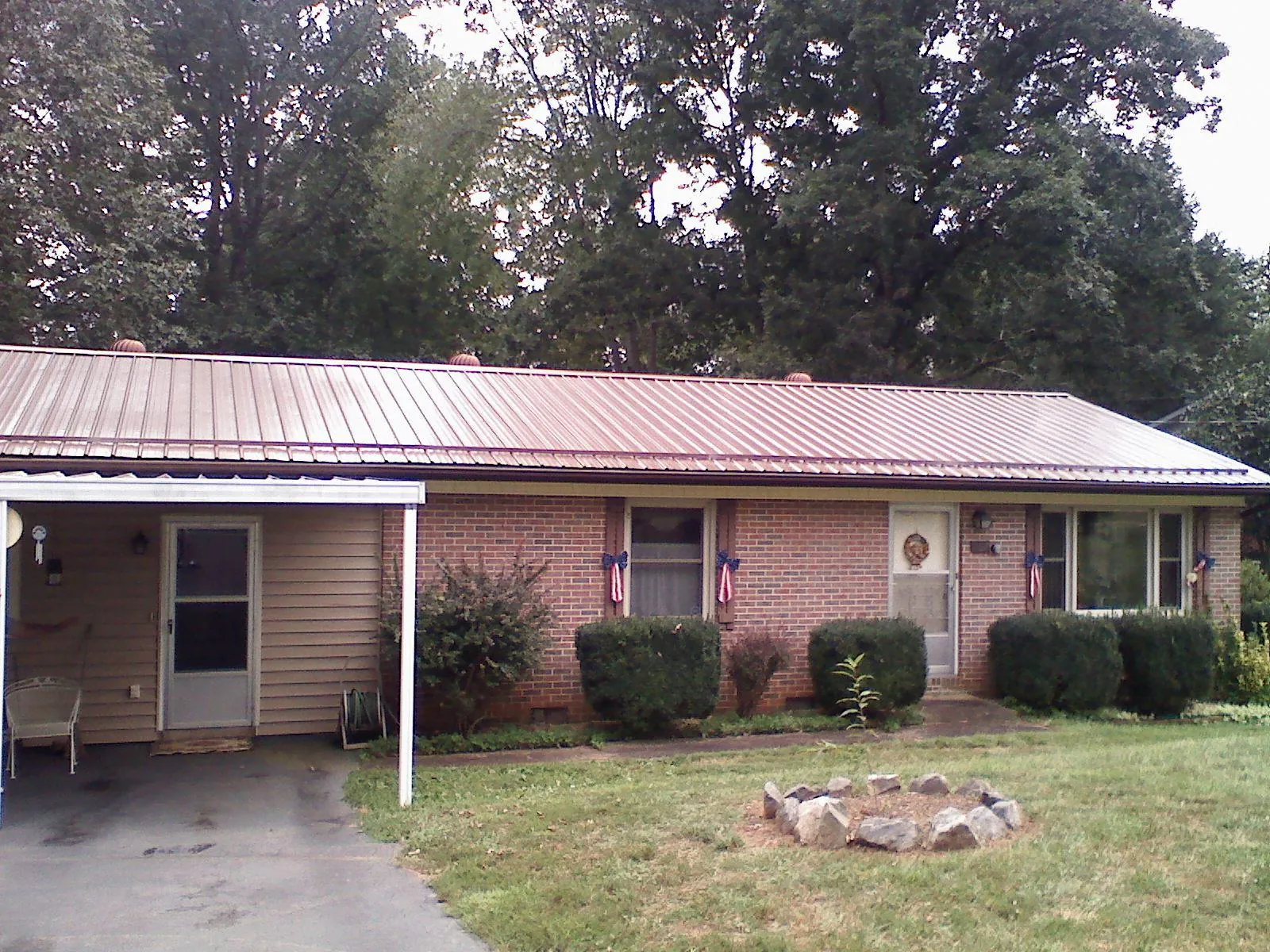 Bronze metal roof and carport on a brick ranch home — Roof Repair work by our crew in Kidder